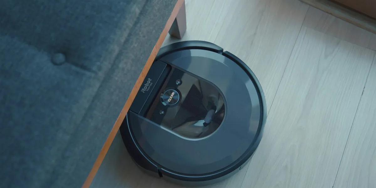 Robot vacuum cleaning next to a sofa