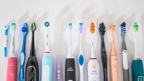 Row of manual and electric toothbrushes against a white background