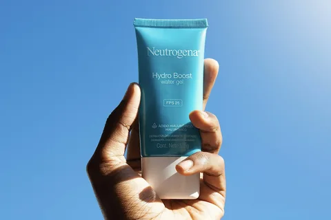 Hand holding a tube of sunscreen